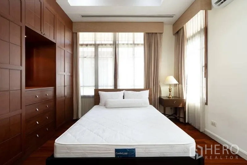 บ้าน ให้เช่าหรือขายในWatthana, Bangkok - ห้องนอนพร้อมตู้บิลต์อินไม้ เตียง และแสงธรรมชาติจากหน้าต่างสูง