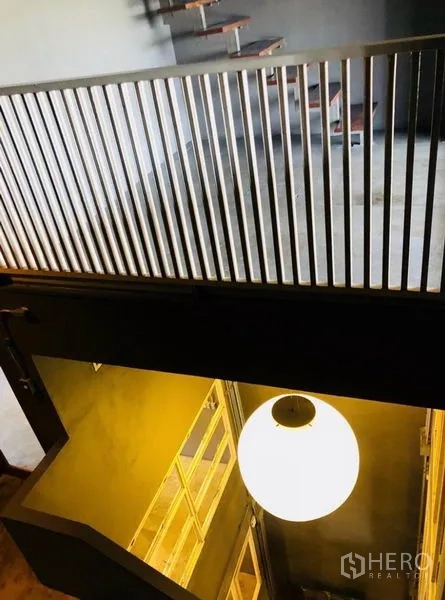 Home Office for rent in Huai Khwang, Bangkok - Stair landing with vertical metal railing overlooking the atrium.