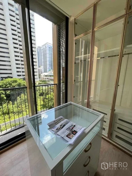 Condominium for rent in Watthana, Bangkok - Walk-in closet with glass wardrobes and display island, floor-to-ceiling windows and city greenery view.