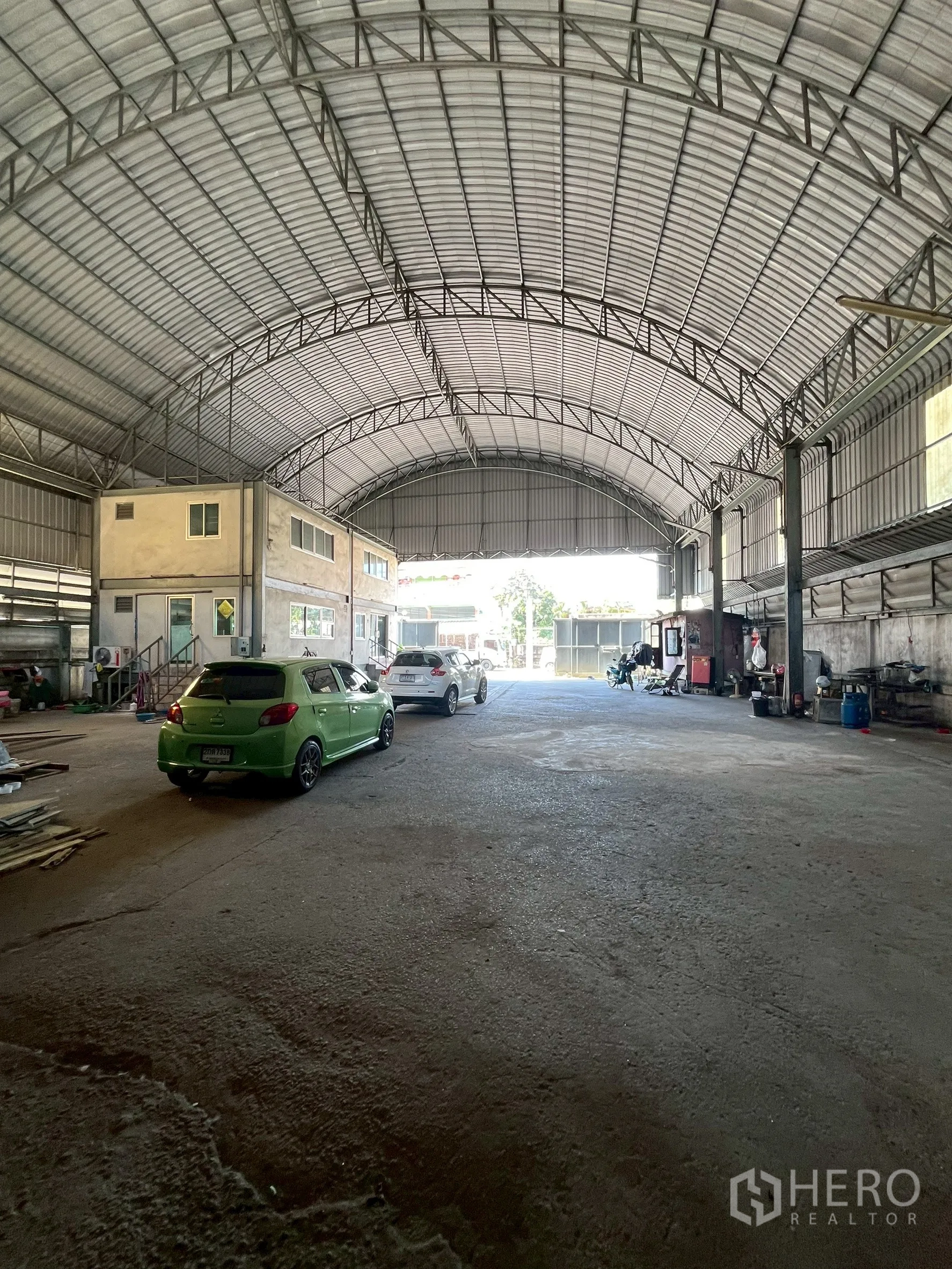 Factory for rent in Phra Pradaeng, Samut Prakan - Spacious factory floor with high arched steel roof and internal two‑storey office block.