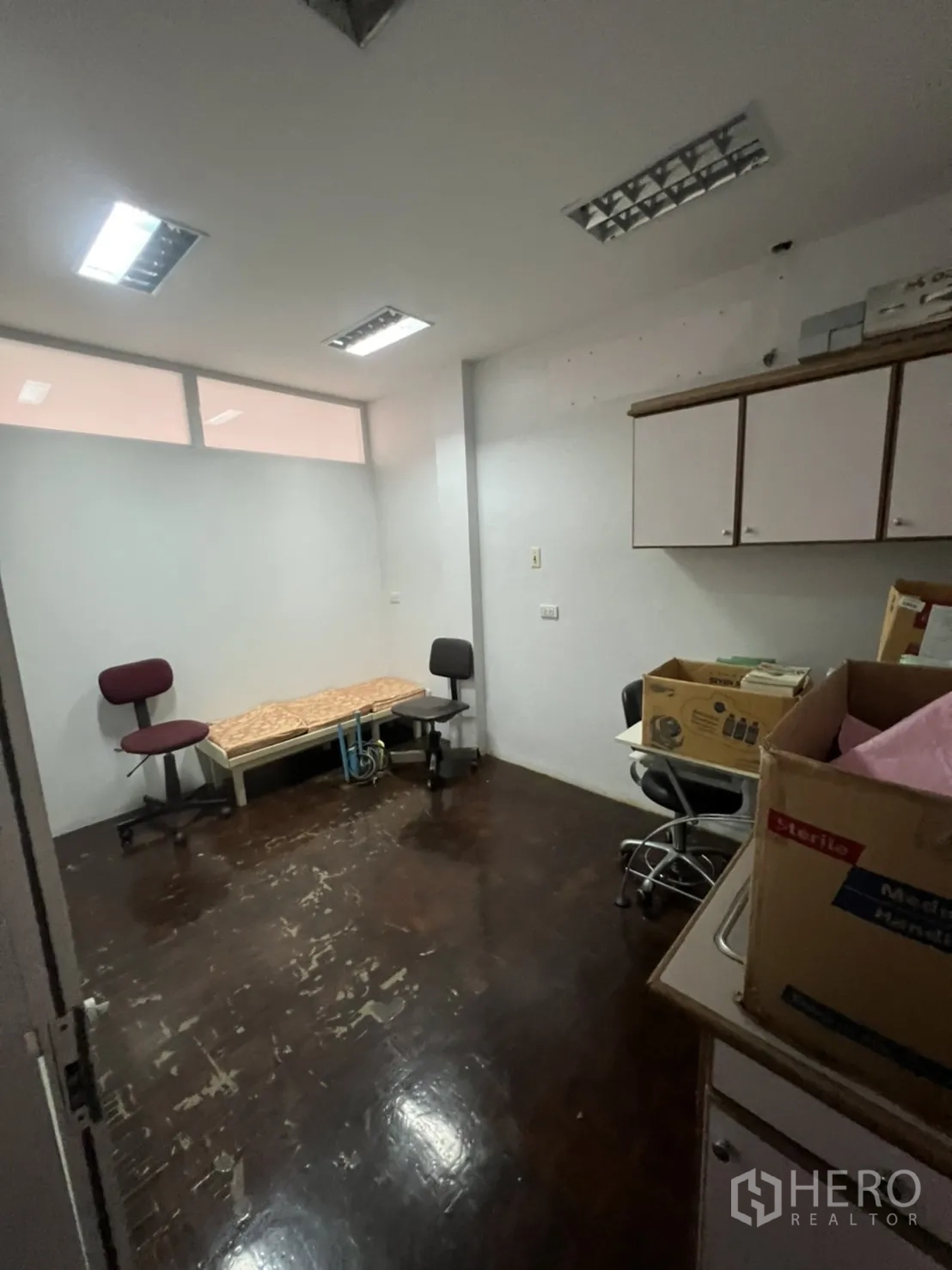 Shophouse for rent in Khlong Toei, Bangkok - Workroom with dark wood floor, cabinets and chairs, suitable for office use.