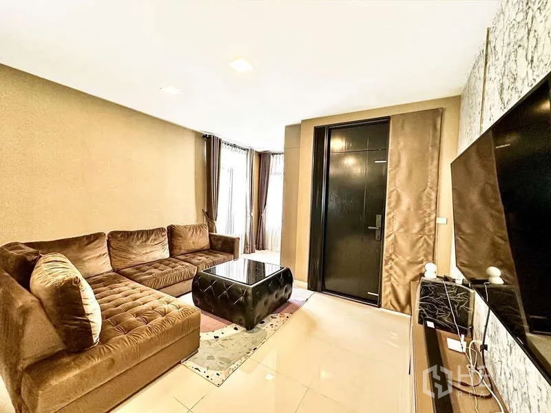Detached House for sale in Bang Phli, Samut Prakan - Cozy living room featuring an L-shaped sofa, TV wall and glossy floor tiles.
