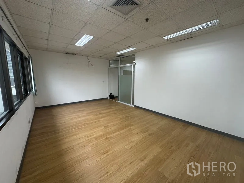 办公空间 出租在Watthana, Bangkok - 大开间工作区，磨砂玻璃入口与木纹地面。
