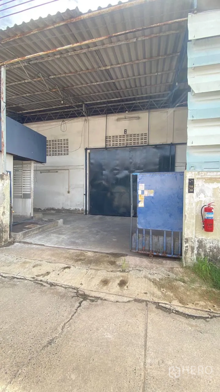工厂 for rent in Bang Phli, Samut Prakan - 工厂正面入口，带雨棚和滑动钢门。