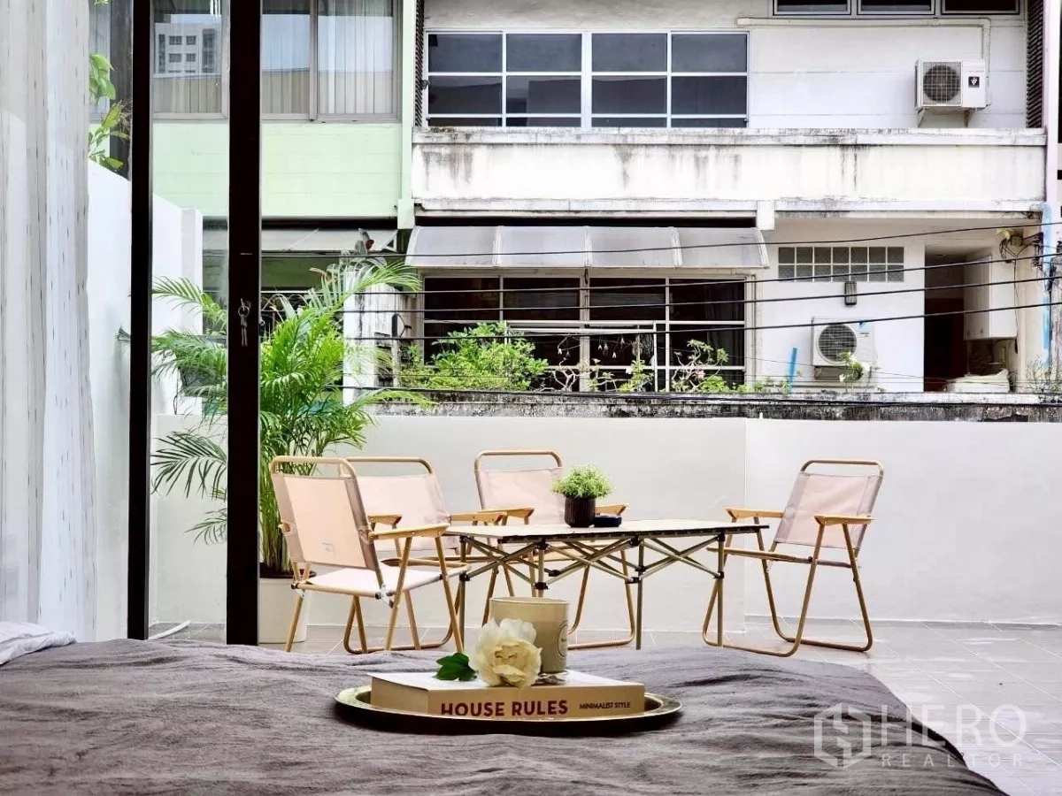 Townhouse for rent in Huai Khwang, Bangkok - View from bedroom to terrace seating through open sliding doors.