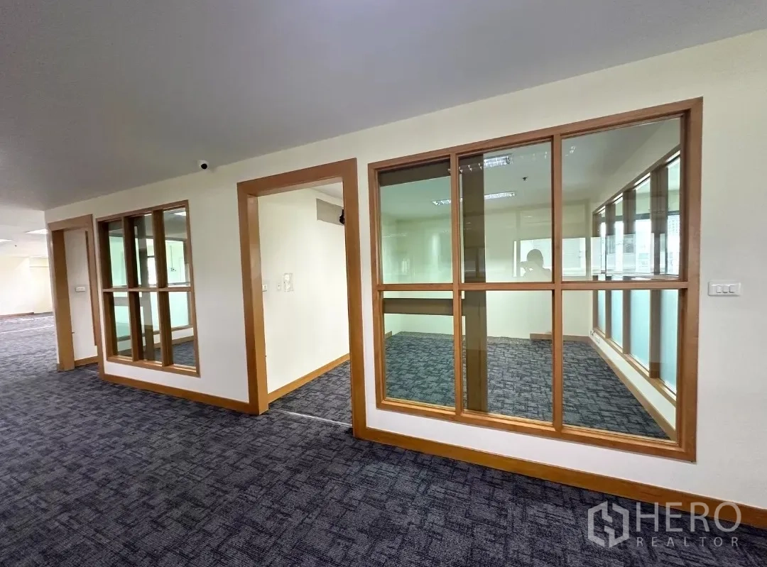 Office Space for rent in Bang Rak, Bangkok - Glass-partitioned meeting rooms with wood frames inside a carpeted office.