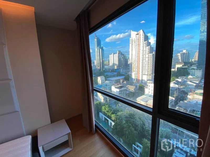 Condominium for rent in Bang Rak, Bangkok - Bedroom corner window showcasing wide city views of Bangkok.