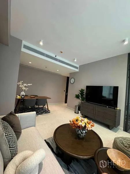 Condominium for rent in Bang Rak, Bangkok - Open-plan living room with sofa, TV console and adjoining dining area