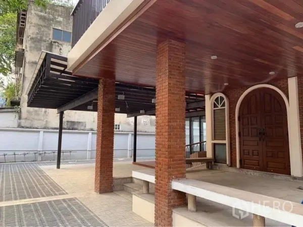 独立式住宅 出租在Ratchathewi, Bangkok - 有顶门廊与车棚，红砖立柱和拱形实木大门。