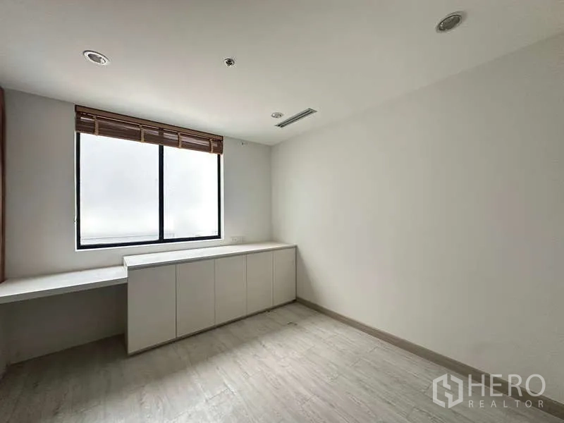 Retail Space for rent in Pathum Wan, Bangkok - Bright room with window, blinds, and built-in storage cabinets.