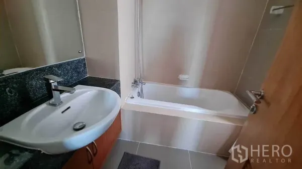 公寓 出租或出售在Watthana, Bangkok - 浴室设浴缸、大片镜面与单盆台面。