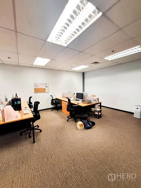 Office Space for rent in Bang Na, Bangkok - Private office area featuring multiple workstations, task chairs and bright fluorescent ceiling lighting.