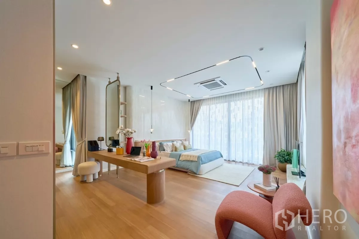 Detached House for sale in Lat Phrao, Bangkok - Spacious bedroom with desk area, pendant lights and wide windows.