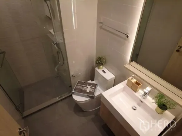 公寓 出售在Watthana, Bangkok - 现代浴室，玻璃淋浴间、马桶与台上盆，配中性色调。