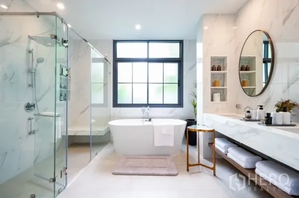 Detached House for sale in Bang Kapi, Bangkok - Luxury bathroom featuring a freestanding tub, glass shower, marble finishes and a large window.