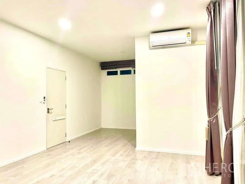 Detached House for rent in Prawet, Bangkok - Long bedroom or flex room with air conditioner, curtains and wood floors.