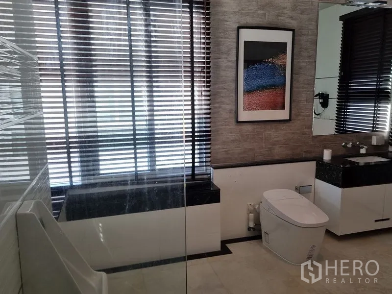 Detached House for sale in Chatuchak, Bangkok - Contemporary bathroom with glass shower, vanity, large mirror and blinds.