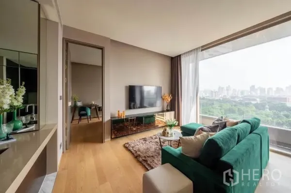 公寓 出租或出售在Bang Rak, Bangkok - 客厅配落地窗，面向公园与天际线，墙挂电视。