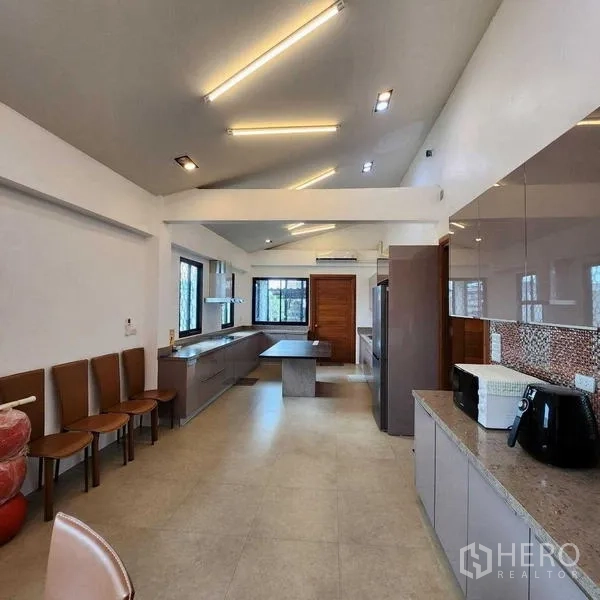 独立式住宅 出售在Phra Khanong, Bangkok - 次厨房视角，长操作台、窗户与条形照明