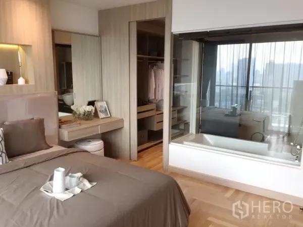 公寓 出售在Watthana, Bangkok - 主卧连接步入式衣橱与玻璃隔断浴室，设浴缸并享城市景观。