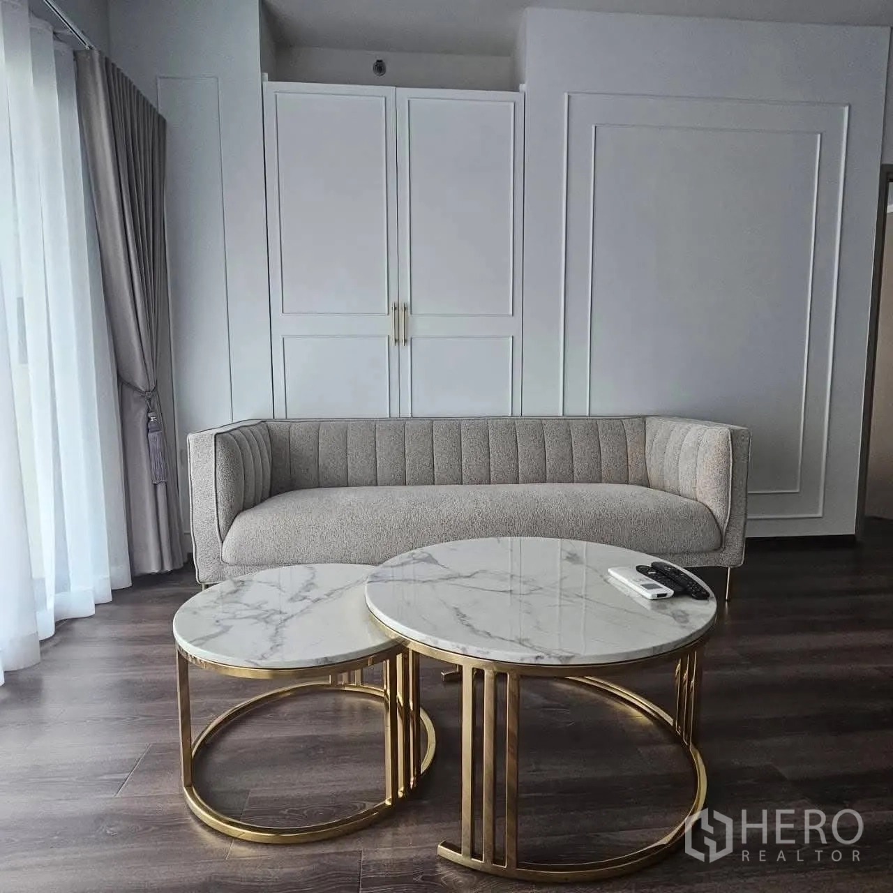 คอนโด for rent in Huai Khwang, Bangkok - ห้องนั่งเล่นสว่างพร้อมโซฟาสีเทา โต๊ะกลางหินอ่อนคู่ และผนังบิลท์อิน