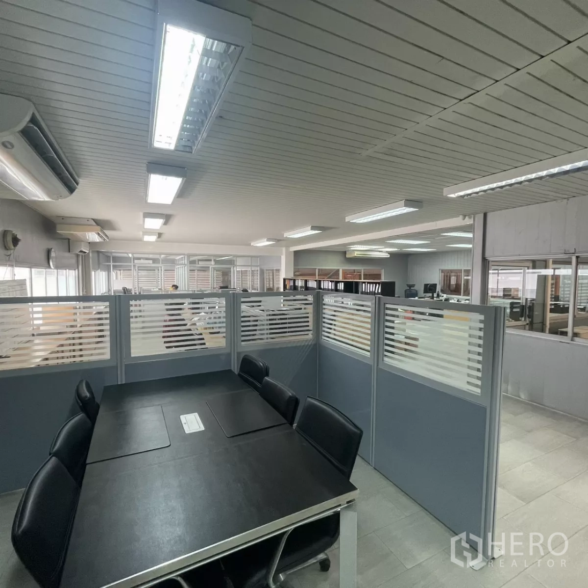 Factory for rent in Bang Phli, Samut Prakan - Second-floor office area with meeting table, partitioned workstations and bright fluorescent lighting.