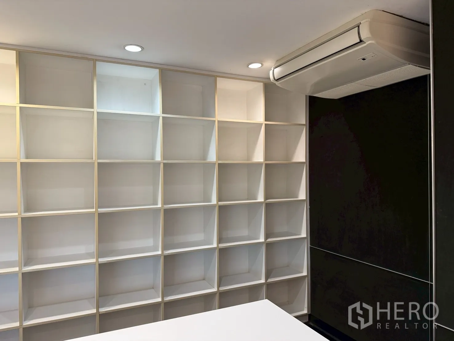 ออฟฟิศ for rent in Huai Khwang, Bangkok - ผนังชั้นวางแบบช่องสี่เหลี่ยม ถัดจากผนังสีดำและเครื่องปรับอากาศเพดาน