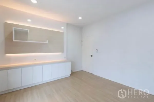 联排别墅 出租或出售在Watthana, Bangkok - 简约客厅配白色内置柜与暖色氛围灯光。