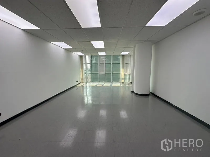 Office Space for rent - Bright office zone with floor-to-ceiling windows, vertical blinds, and rectangular LED panels.