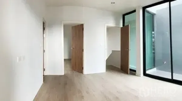Home Office for rent in Don Mueang, Bangkok - Bright bedroom or office space with wood doors and floor-to-ceiling glass to a lightwell.