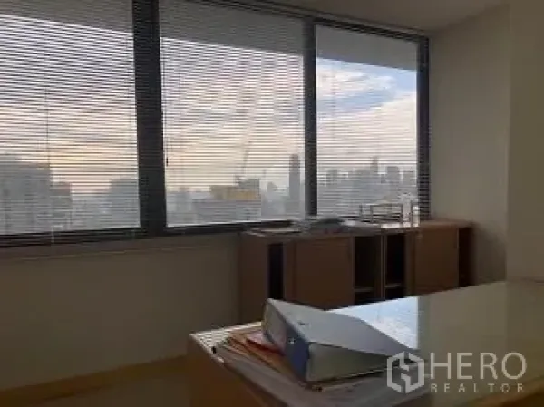 办公空间 出租或出售 - 转角办公室，有百叶窗、书桌与城市景观。
