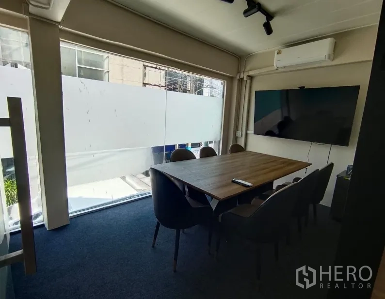 店屋 for rent in Watthana, Bangkok - 临街玻璃会议室，木桌六椅并配壁挂电视。