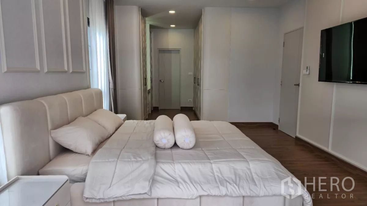 独立式住宅 出租或出售在Bang Phli, Samut Prakan - 主卧视角朝步入式衣帽间走廊，内有到顶衣柜与房门。