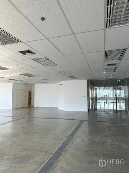 Office Space for rent in Pathum Wan, Bangkok - Spacious office interior with drop ceiling, fluorescent lights and glass entry doors.