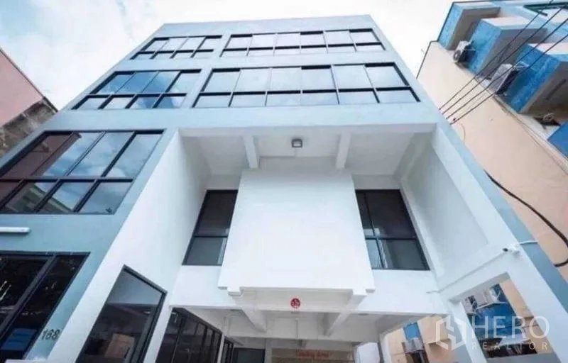 Office Space for rent or sale in Din Daeng, Bangkok - Upward angle of the building’s glass facade and entrance canopy.