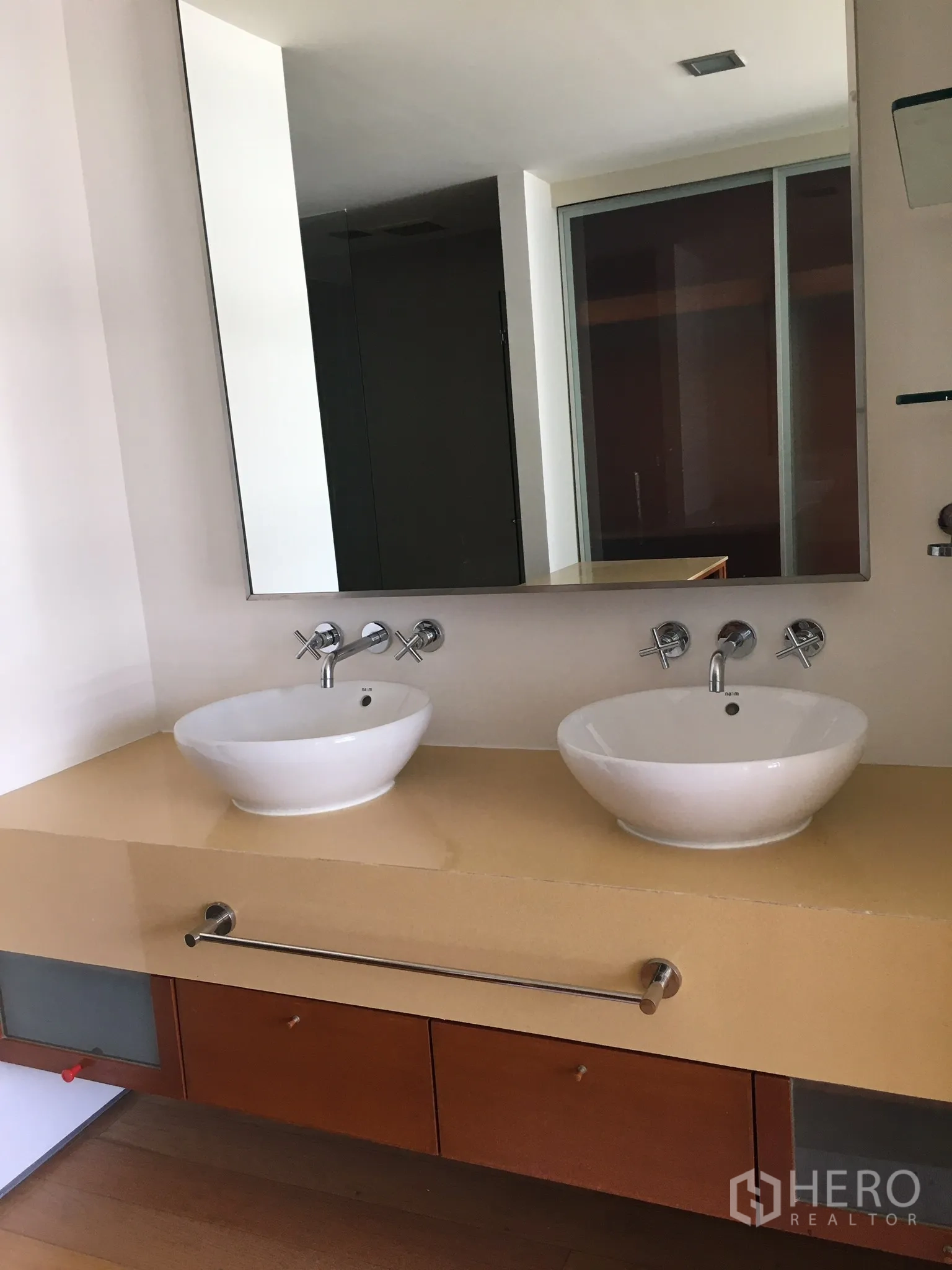 Condominium for rent in Khlong Toei, Bangkok - Bathroom vanity with two round vessel sinks beneath a large mirror.