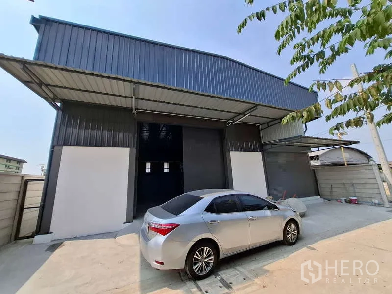 คลังสินค้า ให้เช่าหรือขายในBang Phli, Samut Prakan - ด้านหน้าโกดังโครงเหล็ก พร้อมชายคาสำหรับขนถ่ายและประตูม้วน