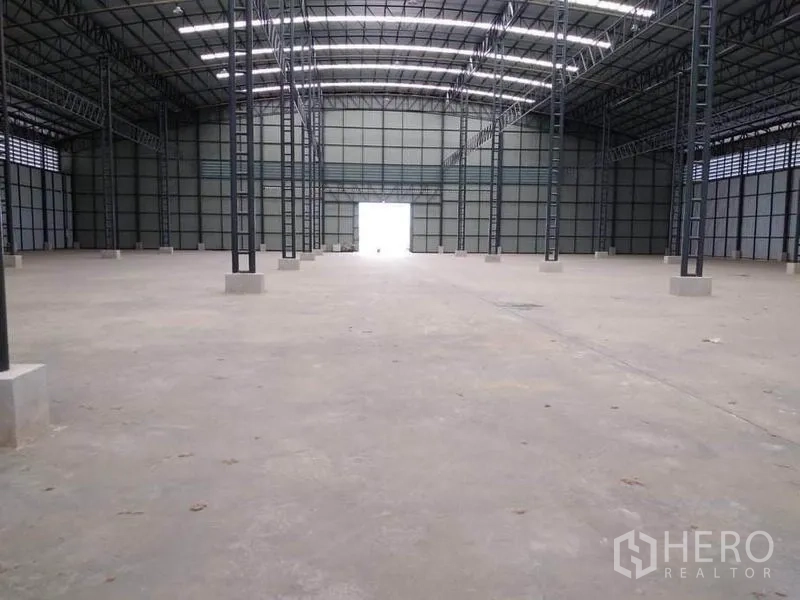 Factory for rent in Mueang Samut Prakan, Samut Prakan - Expansive factory interior with high steel truss roof, skylights and clear-span concrete floor.