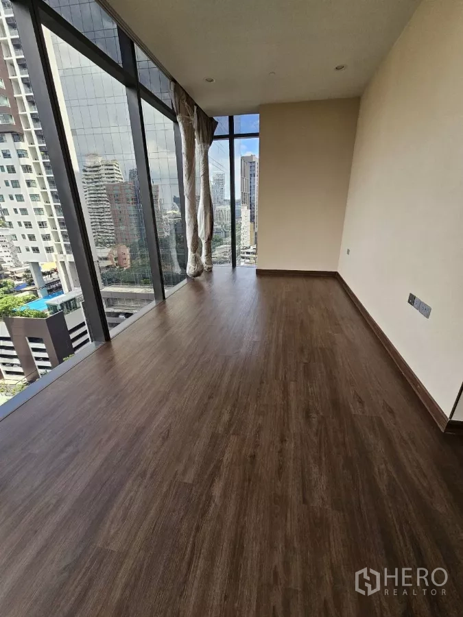 公寓 出租在Watthana, Bangkok - 采光充足的客厅，整面落地窗俯瞰曼谷天际线。