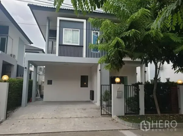บ้าน ให้เช่า - ด้านหน้าบ้านเดี่ยวสองชั้นสไตล์โมเดิร์น มีที่จอดรถในร่มและประตูรั้ว