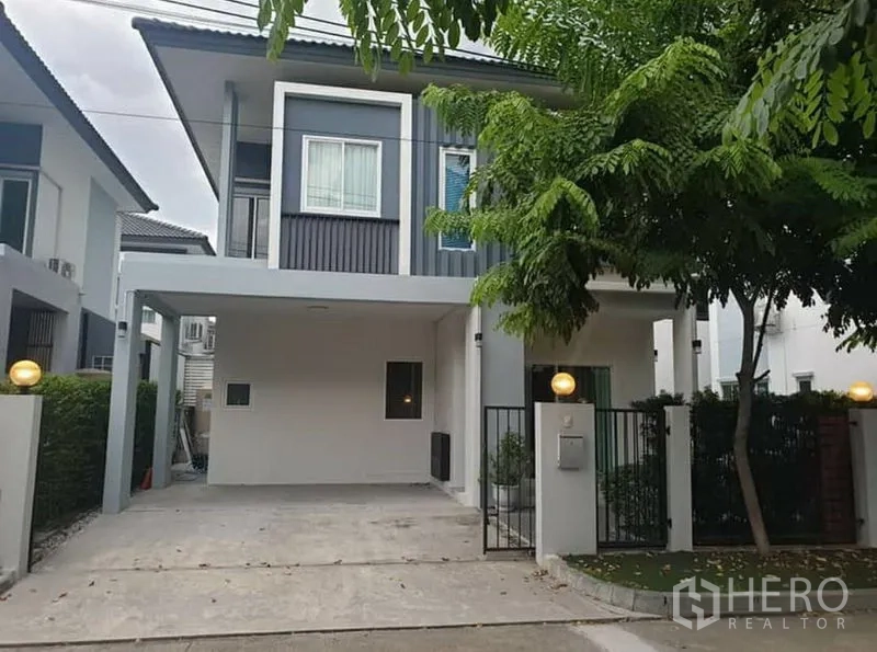 บ้าน ให้เช่า - ด้านหน้าบ้านเดี่ยวสองชั้นสไตล์โมเดิร์น มีที่จอดรถในร่มและประตูรั้ว
