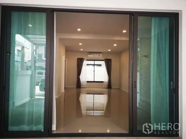 Home Office for rent in Bang Phli, Samut Prakan - Open-plan living room with glossy tile floors, recessed lights and large sliders.