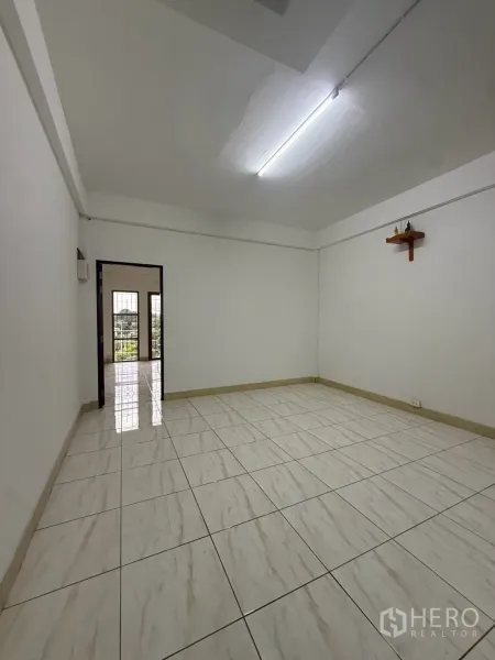 Shophouse for rent in Pak Kret, Nonthaburi - Bright tiled room with white walls and fluorescent lighting.