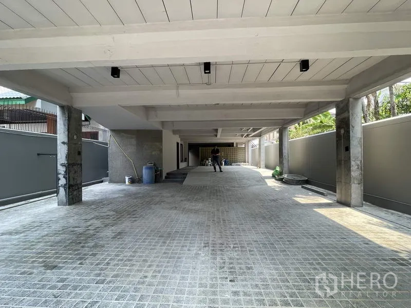 Home Office for rent in Phaya Thai, Bangkok - Wide covered driveway and parking bay beneath the building with concrete columns.