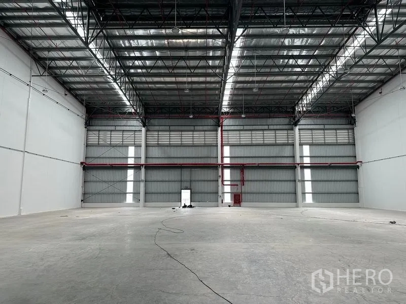 Warehouse for rent in Bang Phli, Samut Prakan - Spacious warehouse interior with high steel truss roof and skylight strips.