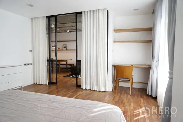 公寓 出租在Watthana, Bangkok - 卧室学习角，内置搁板与书桌，旁为通向客厅的玻璃隔断。