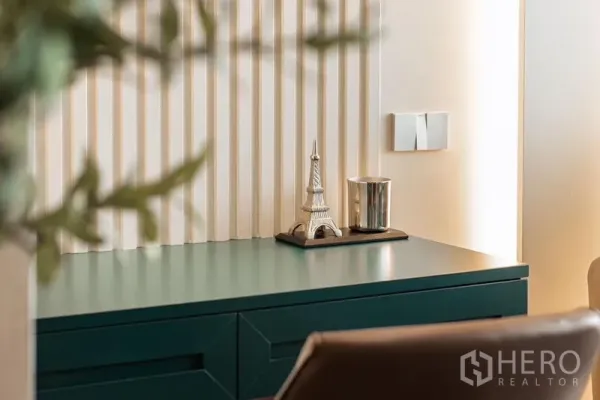 Condominium for rent in Khlong Toei, Bangkok - Close-up of a green console desk with a decorative Eiffel Tower and soft wall lighting.