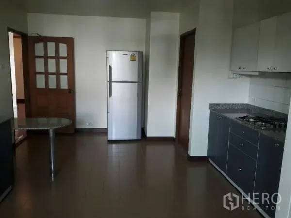 Condominium for rent in Pathum Wan, Bangkok - Practical kitchen with stainless refrigerator, gas cooktop, granite countertop, and tiled floor.