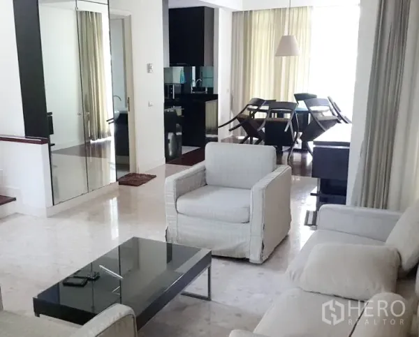 บ้าน ให้เช่าในWang Thonglang, Bangkok - ห้องนั่งเล่นสว่าง มีเก้าอี้นวม โต๊ะกลางกระจก และตู้บานกระจก เชื่อมต่อส่วนทานอาหารและครัว