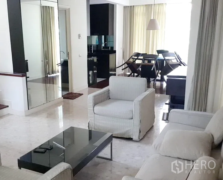 บ้าน ให้เช่าในWang Thonglang, Bangkok - ห้องนั่งเล่นสว่าง มีเก้าอี้นวม โต๊ะกลางกระจก และตู้บานกระจก เชื่อมต่อส่วนทานอาหารและครัว